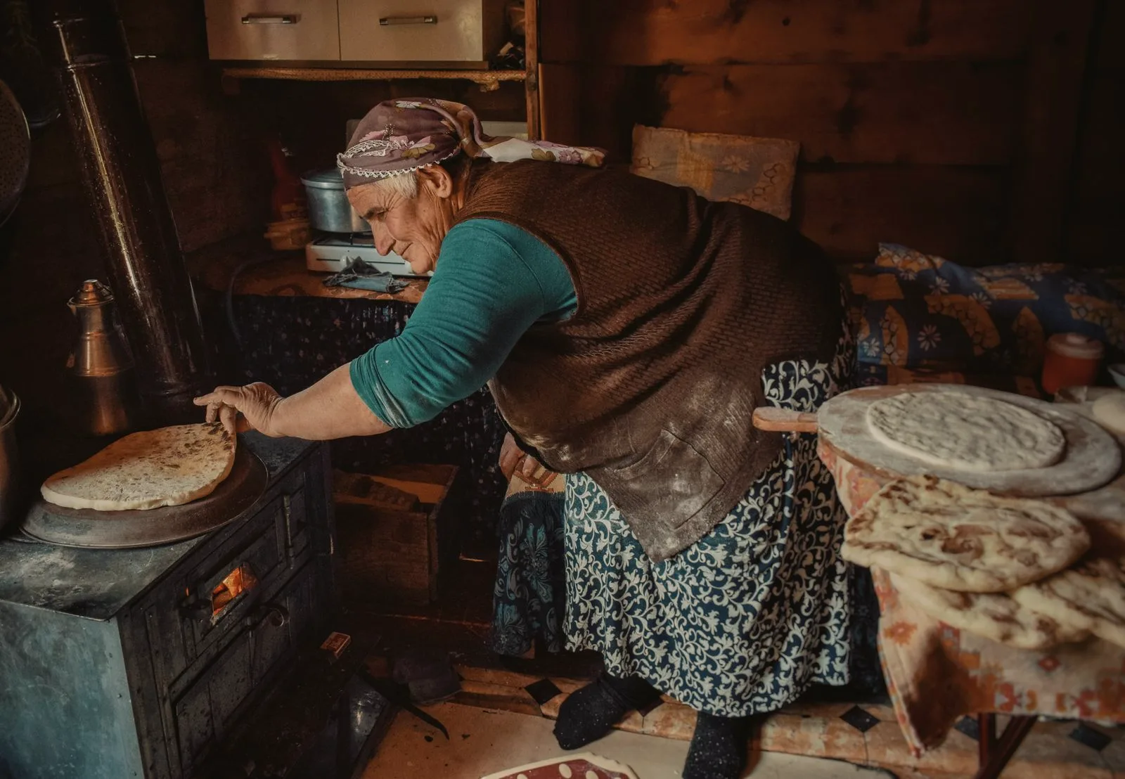 Köy evinde ekmek pişiren bir kadın